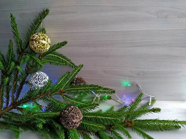 Διακόσμηση του χριστουγεννιάτικου δέντρου: Χριστουγεννιάτικη γιρλάντα και χρυσαφένιες μπάλες. — Φωτογραφία Αρχείου