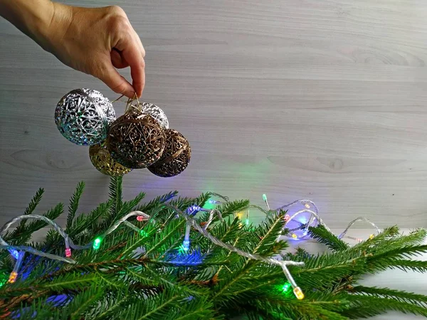 Decorar el árbol de Navidad: guirnalda de Navidad y bolas talladas de oro. — Foto de Stock