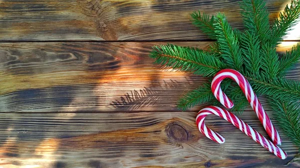 Χριστουγεννιάτικο φόντο για καρτ ποστάλ. κλαδιά ελάτης και γλειφιτζούρια σε ξύλο — Φωτογραφία Αρχείου