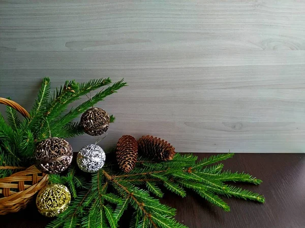 Korg med gran grenar dekorerade med snidade julbollar — Stockfoto