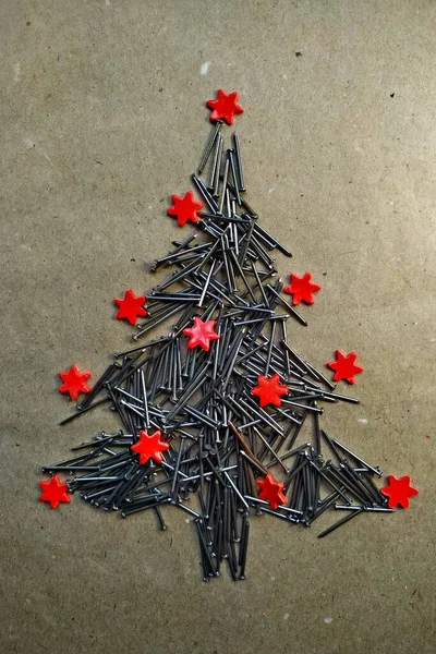 Weihnachtsbaum aus Baunägeln auf Kraftpapier gefaltet — Stockfoto