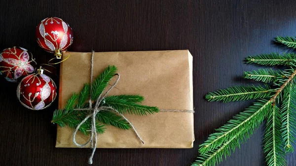 크리스마스 선물이 수공예 종이로 포장되어 있고 전나무 가지들이 모조품으로 장식되어 있다 — 스톡 사진