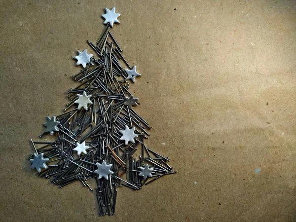 Arbre de Noël plié à partir de clous de construction sur fond de papier kraft — Photo