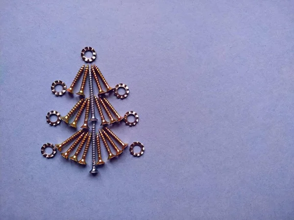 Weihnachtsbaum aus Bauschrauben auf blauem Hintergrund — Stockfoto