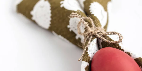 Yeşil peçetedeki kırmızı Paskalya yumurtası doğal iplikle bağlanmış.