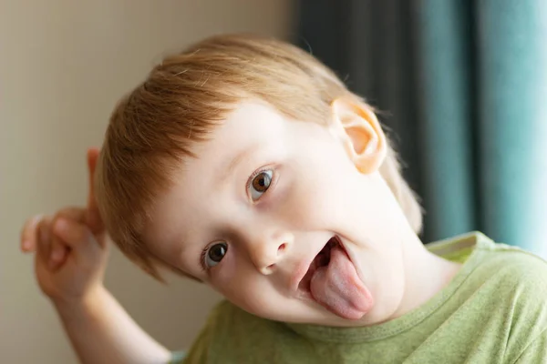 Dilini gösteren iyi bir çocuk. Çocuk dilini çıkartıyor. Kapat..