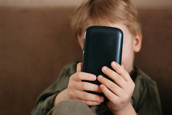 Küçük güzel çocuk telefon kullanıyor, beyaz çocuk akıllı telefonu tut.