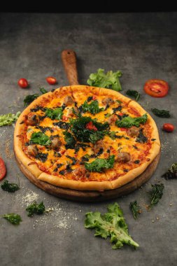 Taze pizza ve ahşap masada yemek malzemeleri.