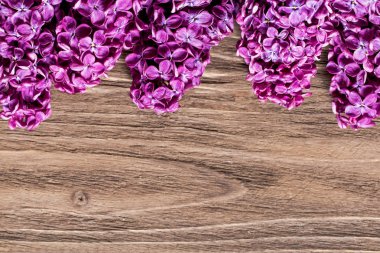 Ahşap masa üstünde taze menekşe leylak çiçek demet