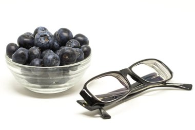 Bilberry beyaz arka plan şeffaf kase. Gözleri konsepti ile katlanmış bir gözlük için tedavi