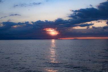 Bulutlar güneş yansıması ile deniz hattı ile arkasında güzel gün batımı
