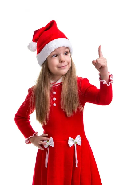 Felice Natale ragazza con un dito puntato verso l'alto, indossando un cappello di Babbo Natale isolato su uno sfondo bianco — Foto Stock