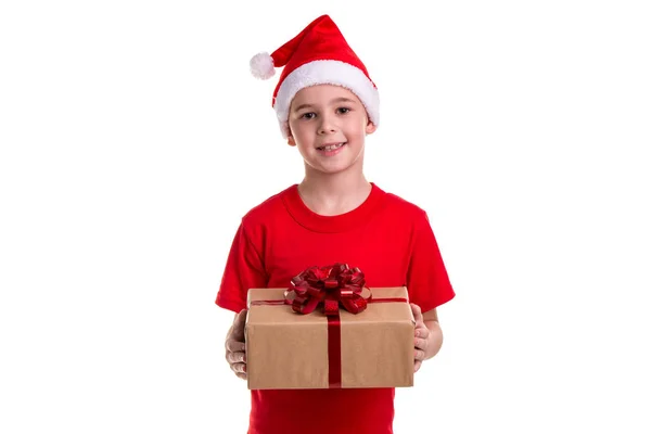 英俊快乐的男孩, 圣诞老人的帽子在他的头上, 手里拿着礼品盒。概念: 圣诞节或新年快乐假期 — 图库照片