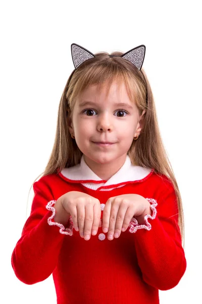 Feliz chica rubia sonriente en un vestido rojo con una banda de orejas de gato en el fondo blanco aislado, sosteniendo sus manos como un gatito —  Fotos de Stock
