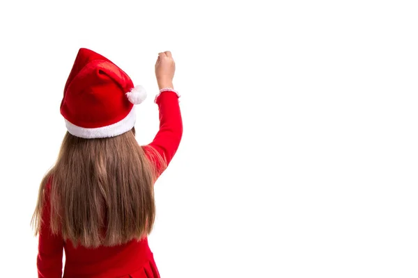 Vista trasera de una niña de Navidad con una mano levantada lista para escribir sobre el fondo blanco aislado —  Fotos de Stock