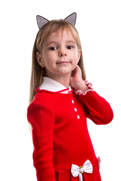 Smiling blond girl in a red dress with a cat ears band on the white isolated background, holding her hand behind the ear. Portrait picture — Stock Photo, Image