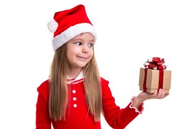 Mutlu Noel kız Holding ve lookning hediye, bir Noel Baba şapkası giyen sol elinde beyaz bir arka plan üzerinde tecrit