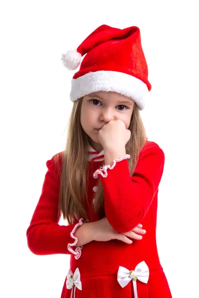 Triste chica de Navidad con el puño debajo de la barbilla, mirando recto, con un sombrero de santa aislado sobre un fondo blanco —  Fotos de Stock