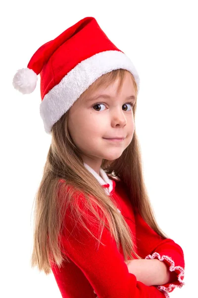 Улыбающаяся кокетливая рождественская девушка в шляпе Санты, изолированная на белом фоне, стоящая в полуобороте. Портретная фотография, крупный план — стоковое фото
