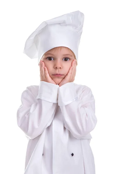 Серйозна дівчина шеф-кухаря білої форми ізольована на білому тлі, тримаючи руки під підборіддям. Портретне зображення — стокове фото