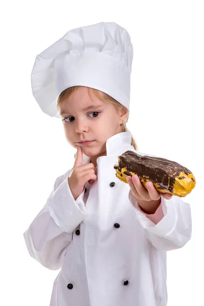 Menina Chef Sério Pensivo Uniforme Cozinheiro Cap Avaliando Eclair Olhar — Fotografia de Stock