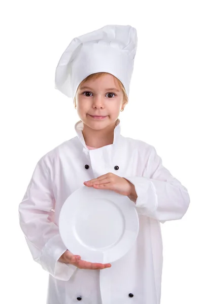 Felice ragazza chef uniforme bianca isolata su sfondo bianco. Tenendo la placca bianca tra le mani davanti a se stessa. Immagine ritratto — Foto Stock