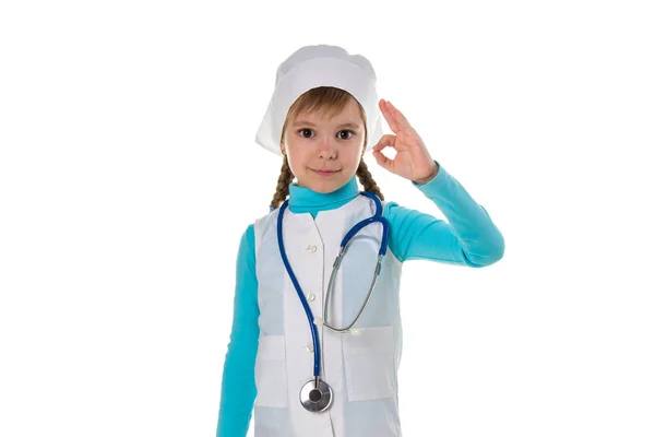 Улыбающаяся молодая женщина-врач, носящая стетоскоп, показывает знак согласия пальцами. — стоковое фото