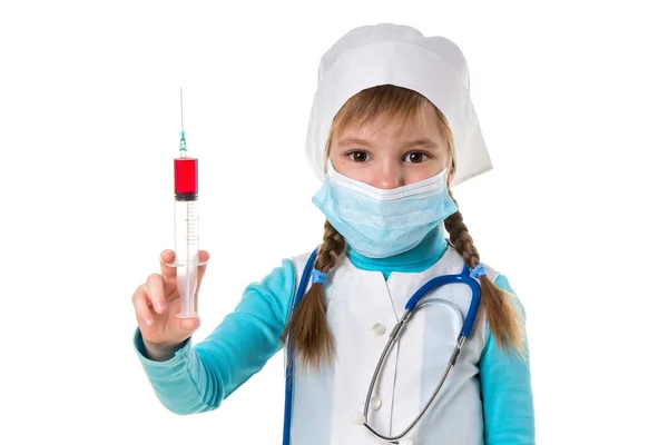 Enfermera con mascarilla médica, sosteniendo la jeringa con un líquido rojo verticalmente, mirando a la cámara, sobre fondo de paisaje blanco —  Fotos de Stock