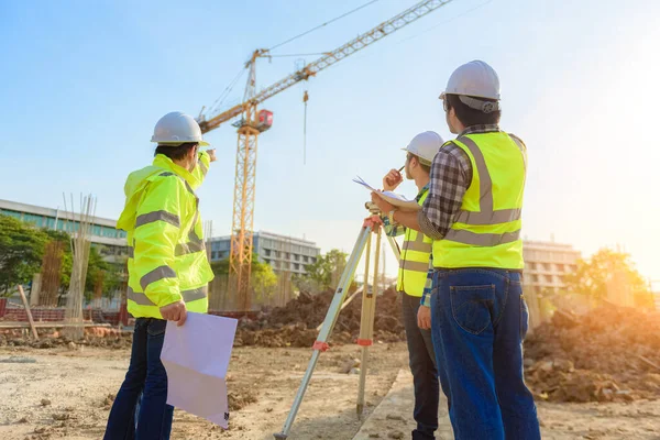 土木技術者は 建設現場の管理チームとの無線通信による作業を検査する — ストック写真