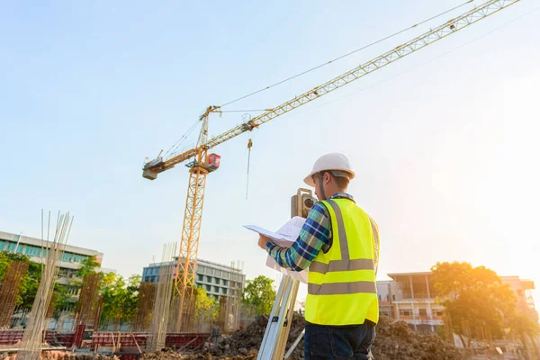 建設現場では 測量技術者がテオドライトを使って共同作業を行っています — ストック写真