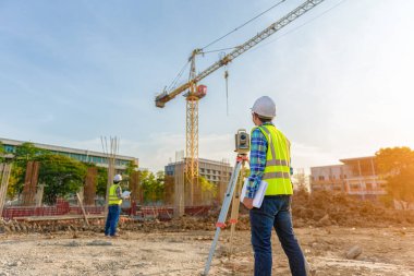 Mühendis, inşaat alanındaki yönetim ekibiyle telsiz iletişimini kullanarak işi denetliyor..