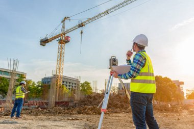 Mühendis, inşaat alanındaki yönetim ekibiyle telsiz iletişimini kullanarak işi denetliyor..