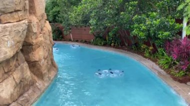 Orlando, FL / USA - 6 / 18 / 20: Parkların Haziran 2020 'de yeniden açılmasının ardından SeaWorld Aquatica' daki tembel nehirde yüzen insanlar