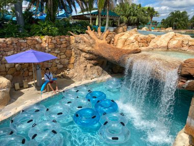 Orlando, FL / USA - 6 / 18 / 20: Parkların Haziran 2020 'de yeniden açılmasının ardından SeaWorld Aquatica' daki tembel nehirde yüzen insanlar