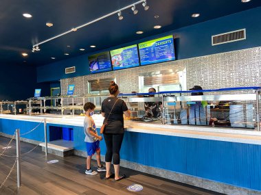 Orlando, FL / USA-7 / 3 / 20: İnsanlar Orlando, FL 'deki Seaworld Tema Parkı' ndaki Waterway Grill 'de yemek siparişi vermek için bekliyorlar.