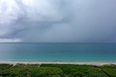 Renkli Atlantik Okyanusu 'nun üzerinde büyük kara bulutlarla bir fırtına..