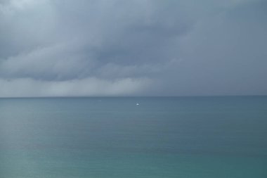 Renkli Atlantik Okyanusu 'nun üzerinde büyük kara bulutlarla bir fırtına..