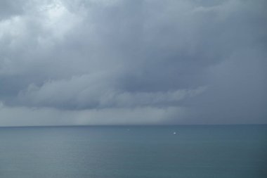 Renkli Atlantik Okyanusu 'nun üzerinde büyük kara bulutlarla bir fırtına..