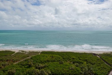 Atlantik Okyanusu 'nun turkuaz mavi sularının güzel güneşli mavi gökyüzü günündeki hava manzarası..