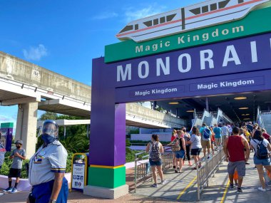 Orlando, FL / USA-7 / 25 / 20: Orlando, FL 'de Walt Disney World Resorts' da kuyruğa girmek için beklerken yüz maskesi takan ve sosyal mesafeli insanlar.