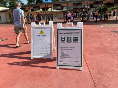 Orlando, FL / USA-7 / 25 / 20: Orlando, FL 'deki Walt Disney Dünya Resorts' taki Covid-19 sağlık riskine ilişkin Sihirli Krallığın girişindeki uyarı işaretleri.
