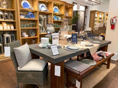 Orlando, FL / USA- 7 / 4 / 20: Orlando, Florida 'daki kapalı bir alışveriş merkezinde Pottery Barn' da bir yemek masası ve hasır sandalyeler.
