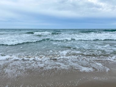 Kuzey Hutchinson Adası Florida kıyılarında güzel ve bulutlu bir günde okyanus dalgaları sahile vuruyor..