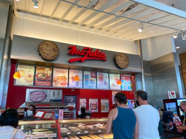 Orlando, FL / USA - 7 / 4 / 20: İnsanlar Orlando, Florida 'daki kapalı bir alışveriş merkezindeki Bayan Fields Cookie perakende mağazasından kurabiye alıyor.