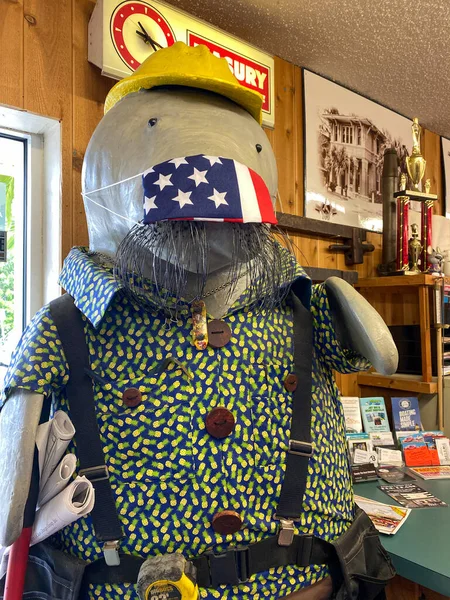 FT Pierce, FL / USA - 6 / 4 / 20: İnşaat işçisi gibi giyinmiş bir Manatee heykeli ve FT, FL 'deki bir Ace Hardware mağazasında koronavirüs onuruna maske takıyor.