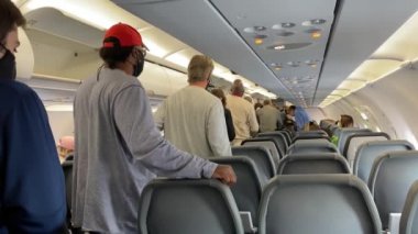 St. Louis, MO / USA - 10 / 2 / 20: İnsanlar yüz maskeleri takarak uçaktan inmek için kuyrukta bekliyorlar ama sosyal mesafeyi aşmıyorlar.