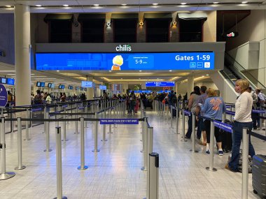 Orlando, FL / USA - 10 / 2 / 20: Orlando Uluslararası Havalimanı MCO 'nun neredeyse boş güvenlik hattı boyunca yürüyen insanlar.