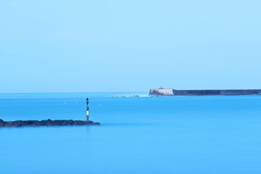 Denizdeki deniz feneri (mavi gökyüzü ve deniz))