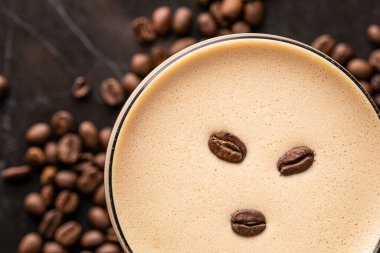 Arka planda fasulye olan bir fincan kahve.