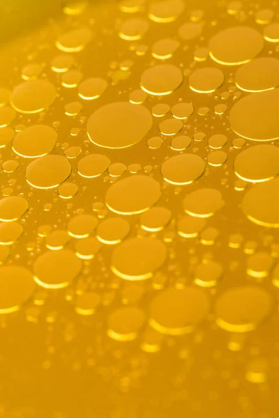 Sarı bir çorbanın yüzeyinde yağ kabarcıkları